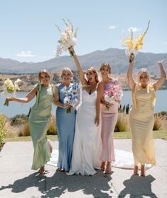 four bridesmaids holding bouquets and flowers in their hands while posing for the camera