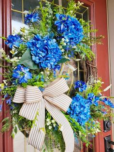 a wreath with blue flowers on the front door