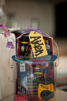 a plastic bucket filled with assorted items on top of a table