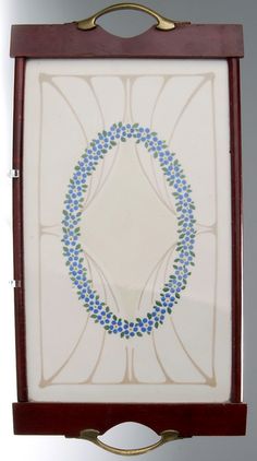 an art piece with blue and green designs on white tiles in a wooden frame hanging from a wall