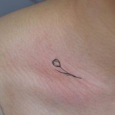 a woman's chest with a small tattoo of a spoon and flower on it