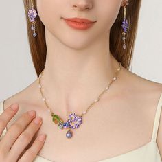 a woman wearing a necklace and earrings with flowers on it