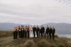 a group of people standing next to each other on top of a grass covered hill