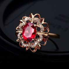 Brand New Ring Made Out Of Rose Gold Plated 925 Sterling Silver With An Oval Shaped Created Ruby Set In The Center In A Halo Shaped Design. The Halo Is 5/8" X 3/16" Large And The Center Stone Is 3/16" X 5/16" Large. The Ring Weighs 6 Grams. R0489-94 Large Ruby Ring, Red Quince Ring, Ruby Nose Pin, Gold Elegant Jewelry, Oval Ruby Ring Design, Gem Rings Stones, Gold Diamond Rings For Women, Spooky Accessories, Ruby Jewelry Ring