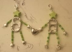 two green and silver earrings with stars on them