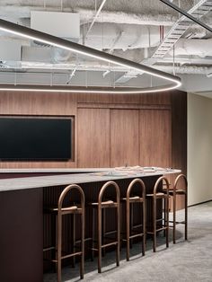 an empty conference room with bar stools and a flat screen tv on the wall