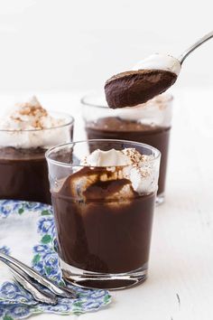 two glasses filled with chocolate pudding and whipped cream