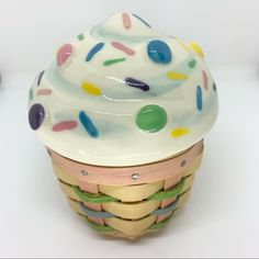 there is a cupcake with sprinkles on it sitting in a basket