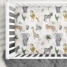 an animal themed crib sheet with zebras, lions and giraffes