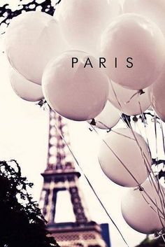 the eiffel tower in paris with white balloons