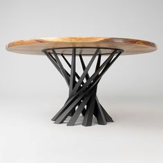 a wooden table with black metal legs and a wood top that has been designed to look like an abstract piece of art