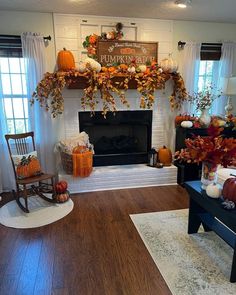 a living room decorated for fall with pumpkins and greenery on the mantel