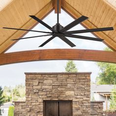 a ceiling fan mounted to the side of a stone fireplace