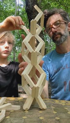 a man and boy are making wooden structures