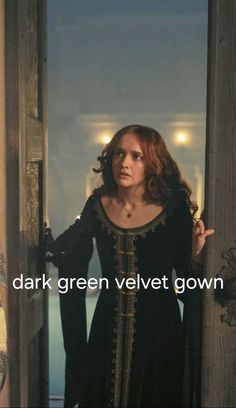 a woman in a black dress is standing by an open door with the words dark green velvet gown