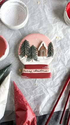 some christmas decorations are sitting on a table with red and white paint, candy canes, and other items