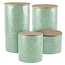 three green canisters with wooden lids and designs on the front one has a wood lid