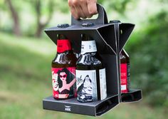 a person holding a beer bottle holder in the shape of an upside down shelf with two bottles on it