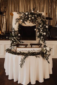 a white table topped with flowers and greenery