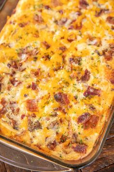 a cheesy casserole with bacon and cheese in a glass dish on a wooden table