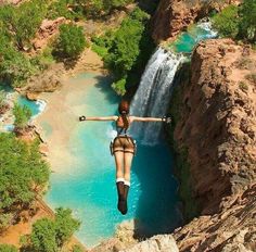 a woman hanging from the side of a waterfall