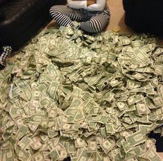 a woman sitting on the floor covered in money