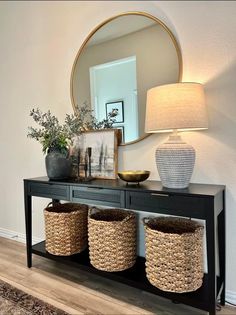 a console table with three baskets under a mirror