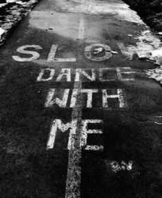 a sidewalk that has some writing on the side of it in black and white colors