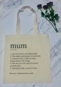 a tote bag sitting on top of a marble table next to a bouquet of flowers