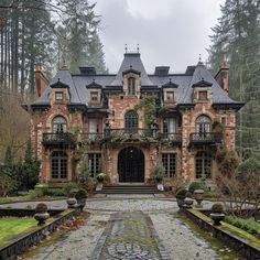 a large brick building with lots of windows and plants on the front entrance way, surrounded by trees