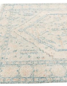 an antique rug with faded blue and beige colors