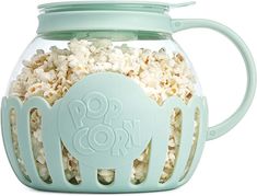 a glass jar filled with popcorn sitting on top of a table