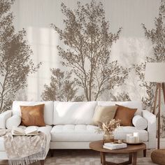 a living room with a white couch and brown pillows on the floor next to a coffee table