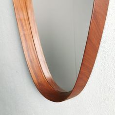 a wooden mirror mounted to the side of a wall