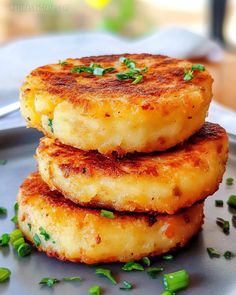 three fried food items stacked on top of each other with green onions and parsley