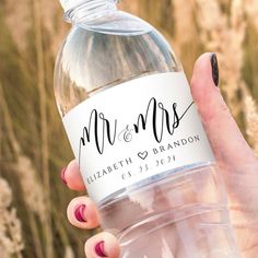 a person holding a water bottle with the word mr and mrs on it