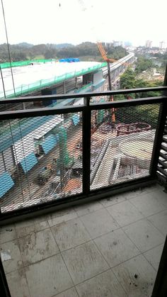 the view from inside an industrial building looking down on a construction site and train tracks