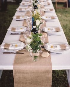 a long table is set with place settings for dinner