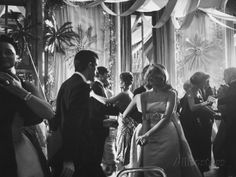 a black and white photo of people dancing at a formal event in the 1950's