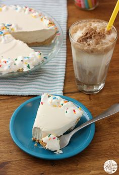 a slice of cake on a blue plate with a fork next to it and a drink