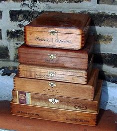 three wooden boxes stacked on top of each other in front of a brick wall and floor