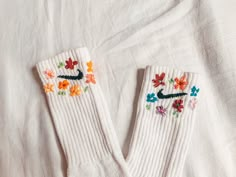 a pair of white socks with embroidered flowers on them