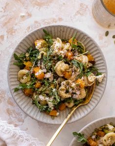 two bowls filled with pasta and vegetables on top of a table