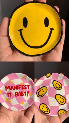 a hand holding a paper plate with a smiley face on it and the words manfest it baby painted on it