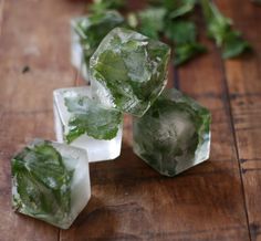 three ice cubes with green leaves on them