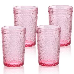 four pink glass cups sitting next to each other