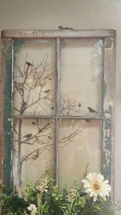 an old window is decorated with flowers and birds on the windowsill, as well as some branches