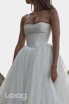 a woman in a white wedding dress is posing for the camera with her hand on her hip