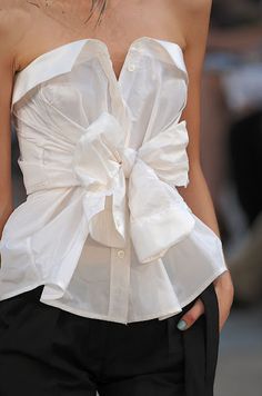 the back of a woman's white shirt with a large bow on it and text that reads, 6 stylish ways to wear a white shirt