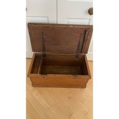 an old wooden trunk sitting on the floor in front of a door with two handles